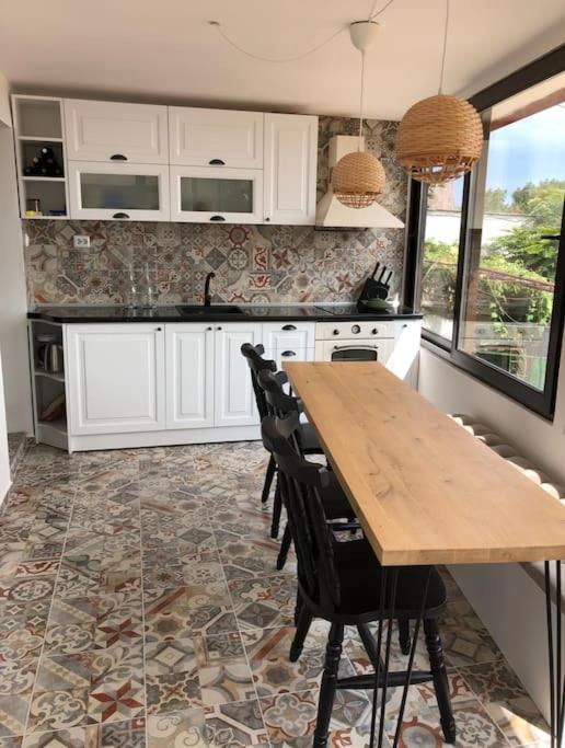 a kitchen with white cabinets and a wooden table at Studio with a sea view in Balchik