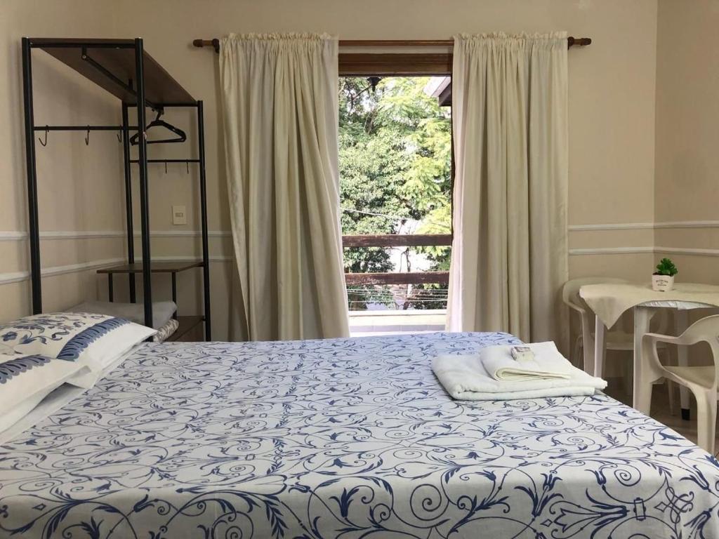 um quarto com uma cama grande e uma janela em Mansão Adalgisa em Osasco