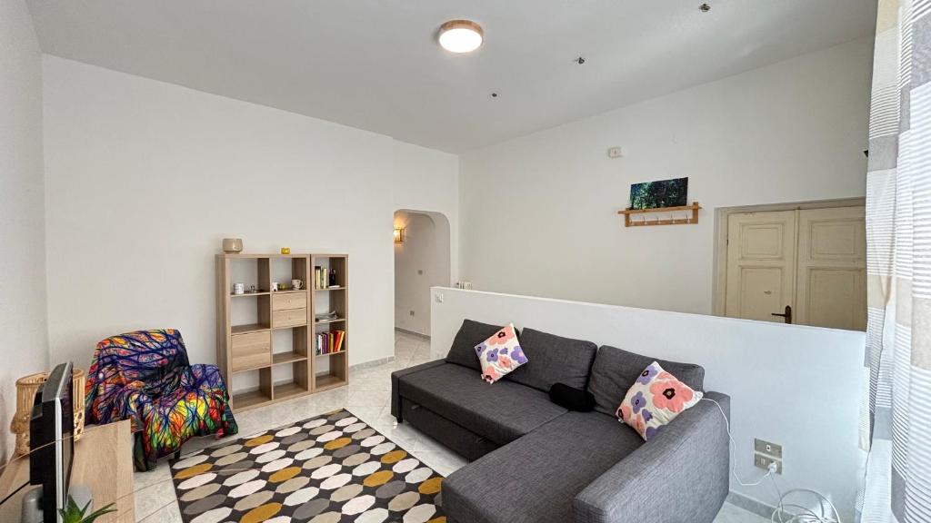 un soggiorno con un divano grigio e un tappeto a quadri di Mazzini Bilo Roseto Vacanza a Roseto degli Abruzzi