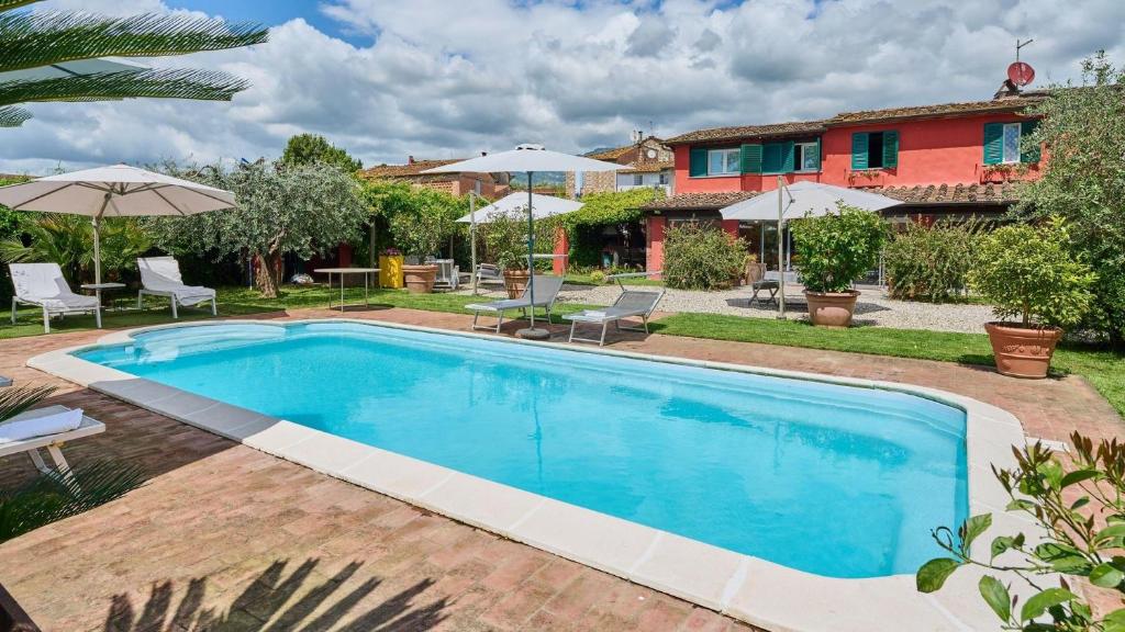 a swimming pool in a yard with umbrellas at Casa Rocchi in Capannori