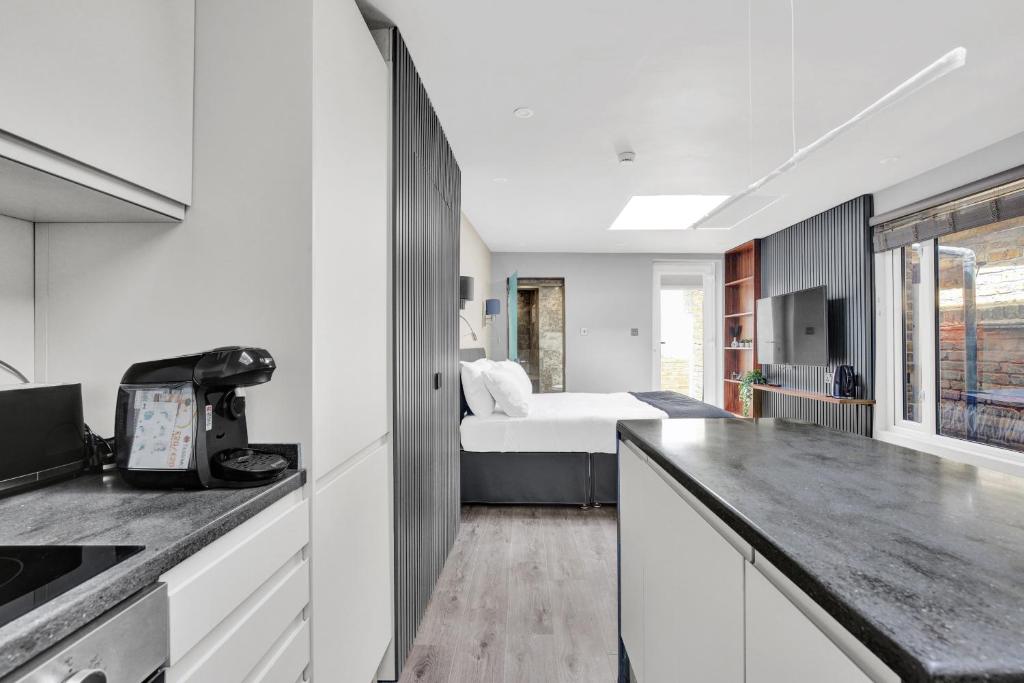 a white kitchen with a bed in a room at Skyline Studios in London