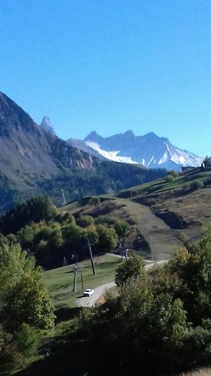 - une vue sur une vallée avec des montagnes enneigées dans l'établissement Le Corbier, bel appartement bien exposé, à Villarembert