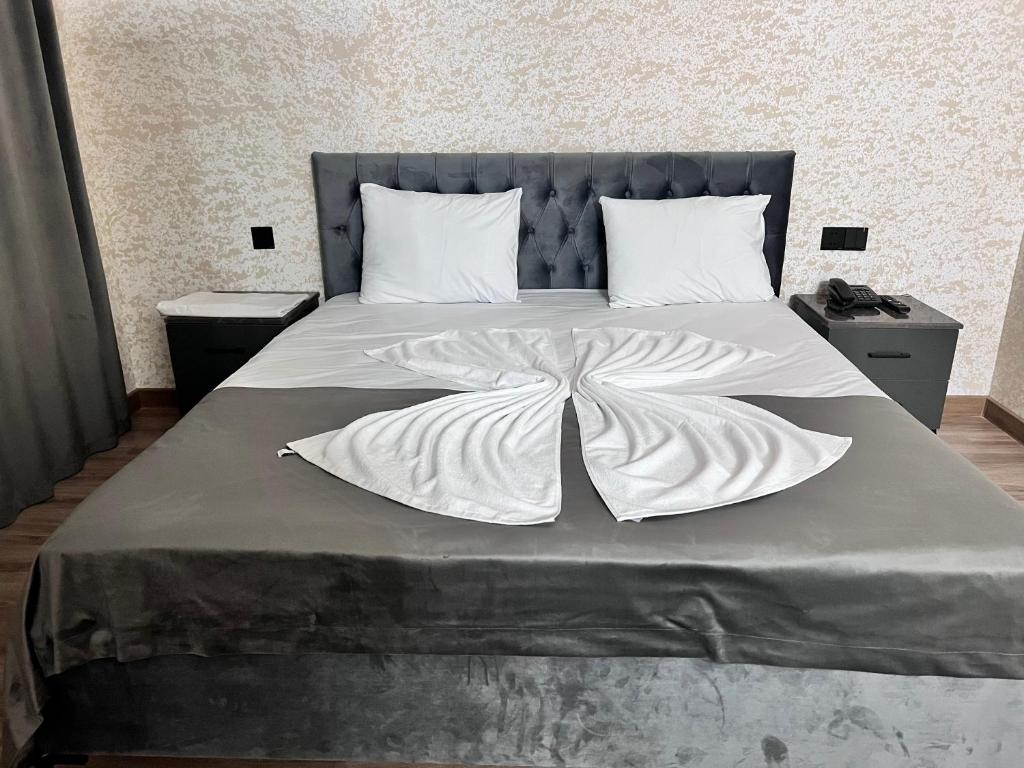 a bed with a white blanket on top of it at Avrasya Hotel in Baku