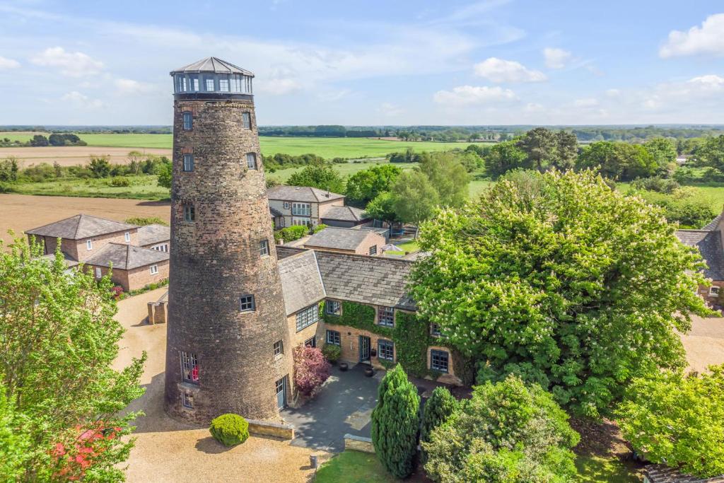 an aerial view of a house with a tower at The Old Mill, 7 storey,, dog friendly outdoor pool & bbq in Stoke Ferry