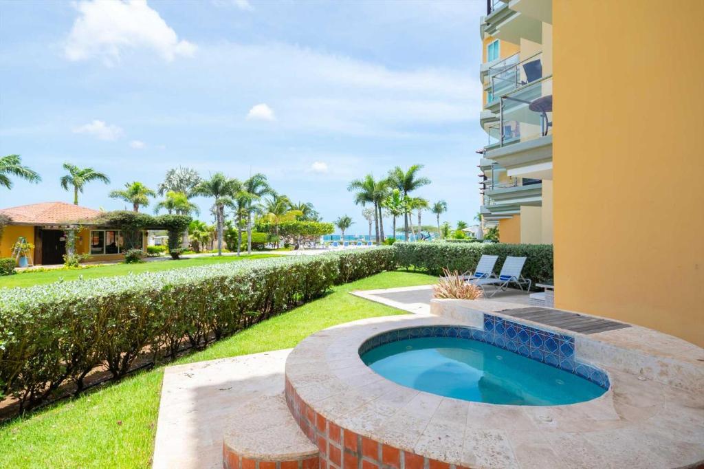 a backyard with a swimming pool and a building at Beachfront - Garden Delight 3BR condo - E125 in Palm-Eagle Beach