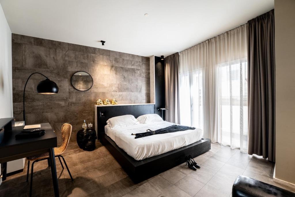 a bedroom with a large bed and a desk and a desk at Neko Boutique Hotel in Cagliari
