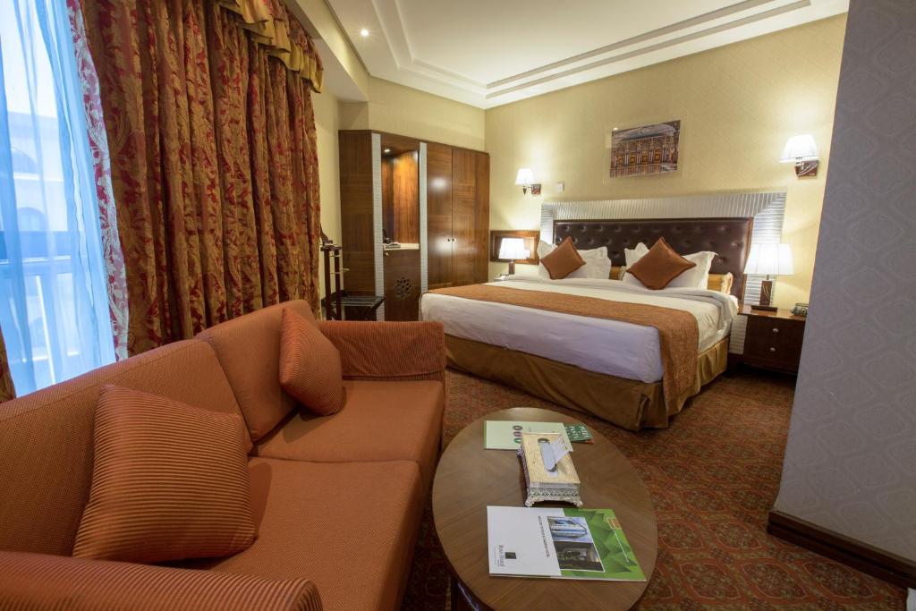 Ruve Al Madinah Hotel في المدينة المنورة: غرفة فندقية بسريرين واريكة