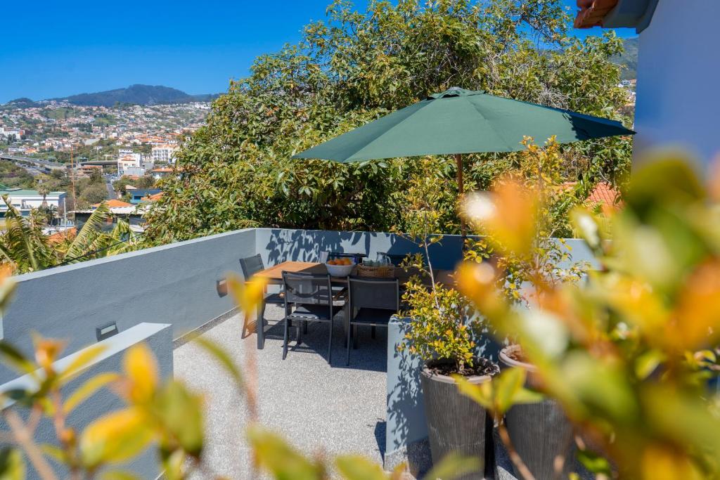 a patio with a table and an umbrella at Achada Sol in Funchal