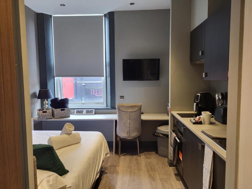 Tren-D Luxe Studio Apartment Room 3 - Contractors, Relocators, Profesionals, NHS Staff Welcome في سندرلاند: غرفة صغيرة بها سرير ومكتب ونافذة