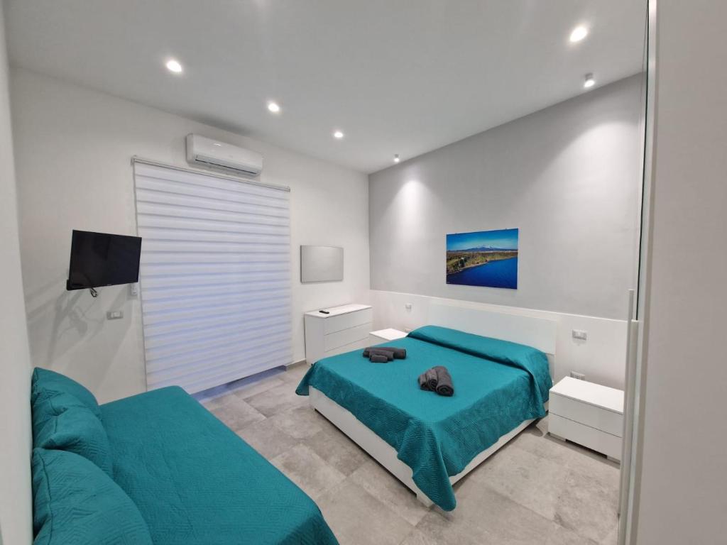 ein Schlafzimmer mit einem blauen Bett und einem Sofa in der Unterkunft Al Vicolo in Acireale