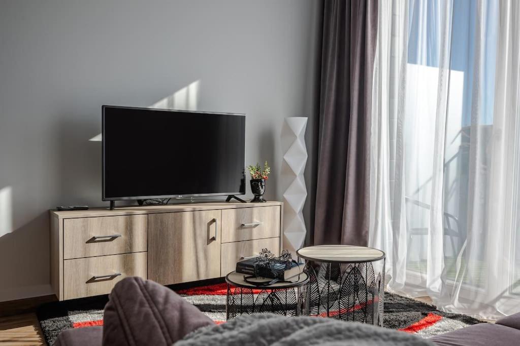 a living room with a flat screen tv on a dresser at Home sweet home, cozy apartments, free underground parking, long stays welcome in Vilnius