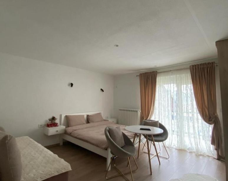 1 dormitorio con 1 cama, mesa y sillas en Rooms Lida & Friendly home en Plav