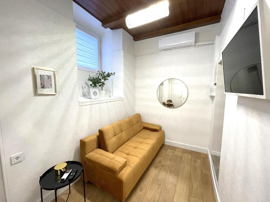 a living room with a couch and a tv at Green Bridge Studio in Vilnius