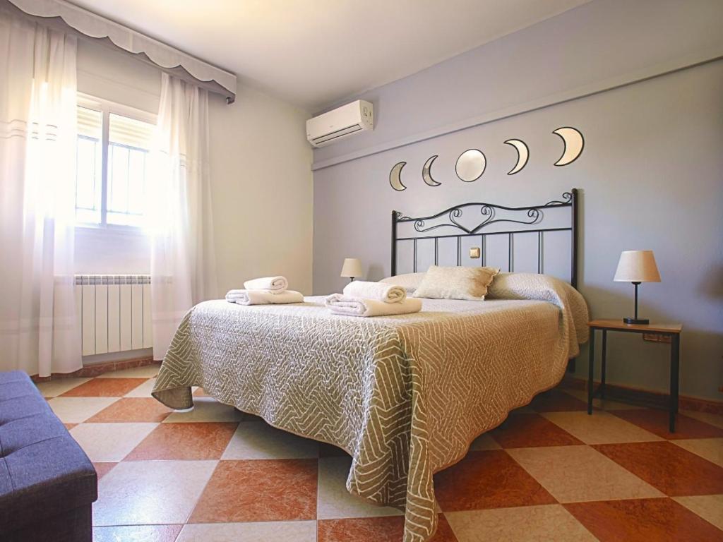1 dormitorio con 1 cama con toallas en Casa Rural Los Mayorales II Apartamento en La Garrovilla