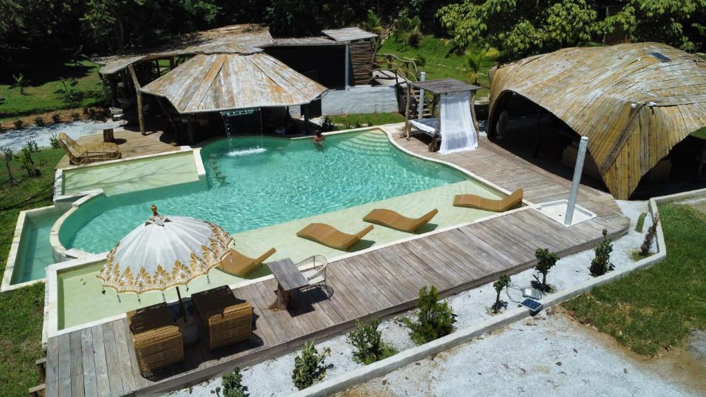 einen Blick über einen Pool mit Stühlen und einem Sonnenschirm in der Unterkunft Akasha suites in Doradal