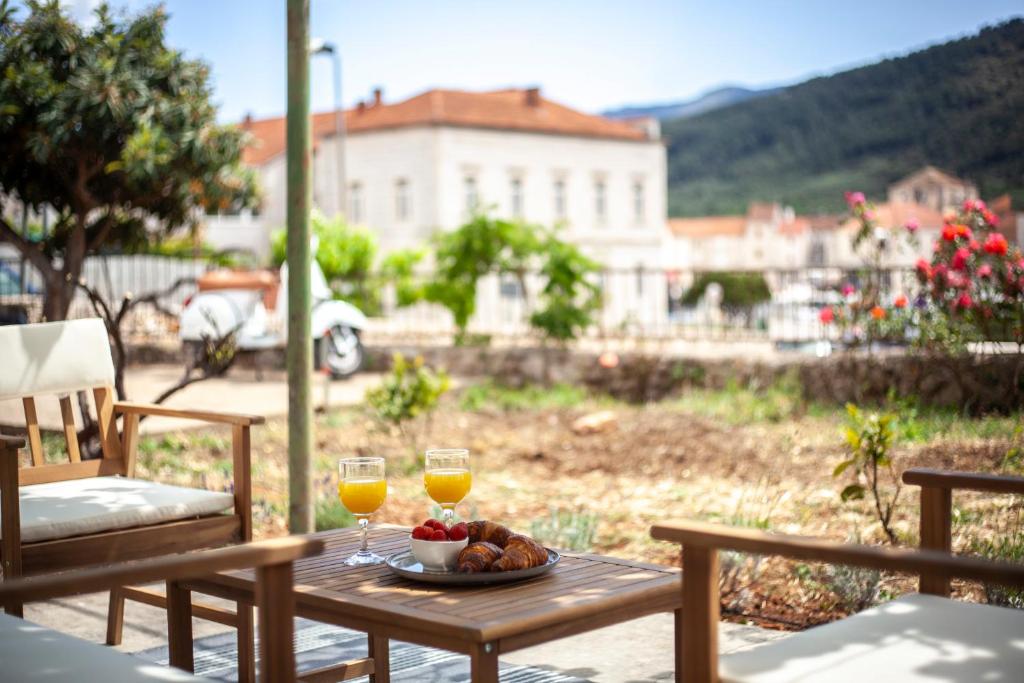 a table with a plate of food and two glasses of wine at Casa Faria in Stari Grad