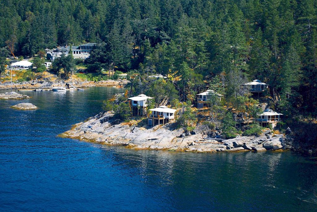 eine Insel inmitten eines Flusses mit Häusern in der Unterkunft Rockwater Secret Cove Resort in Halfmoon Bay