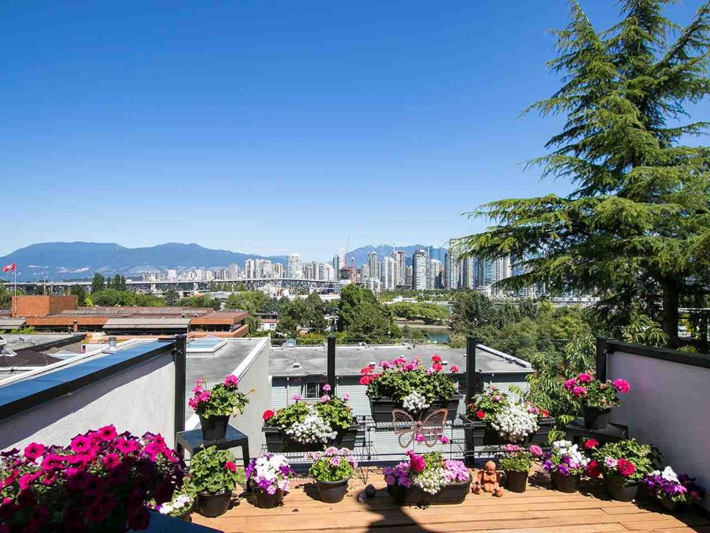 einen Balkon mit Topfblumen und Stadtblick in der Unterkunft Billion Dollar views in a Beautiful Fairview Slopes Heritage House in Vancouver