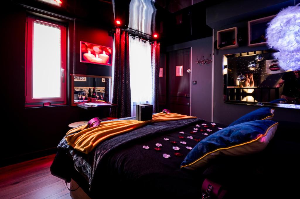 a bedroom with a bed with a comforter and a window at Loveroom sauna, balnéo, parking privé dans le centre de Honfleur in Honfleur
