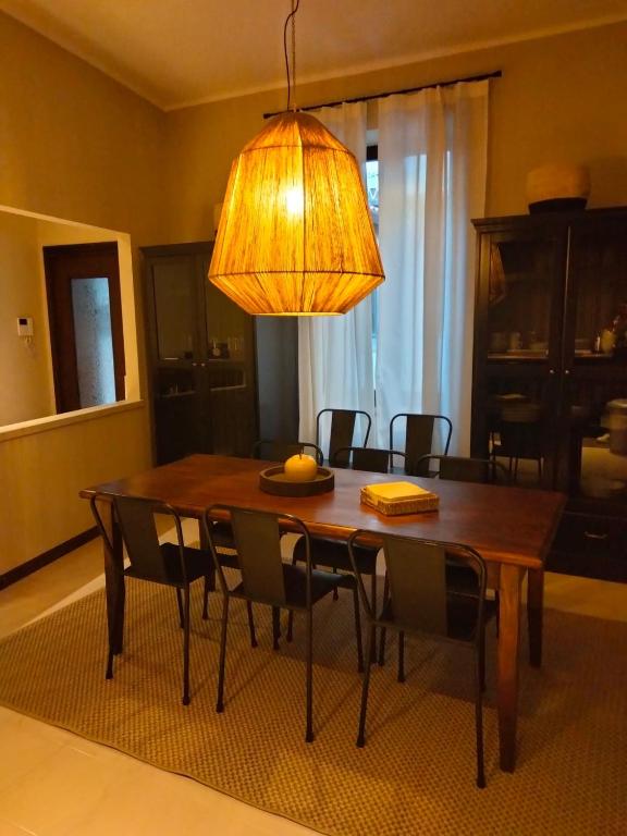 a dining room table with chairs and a light at Rota's House III in Bergamo