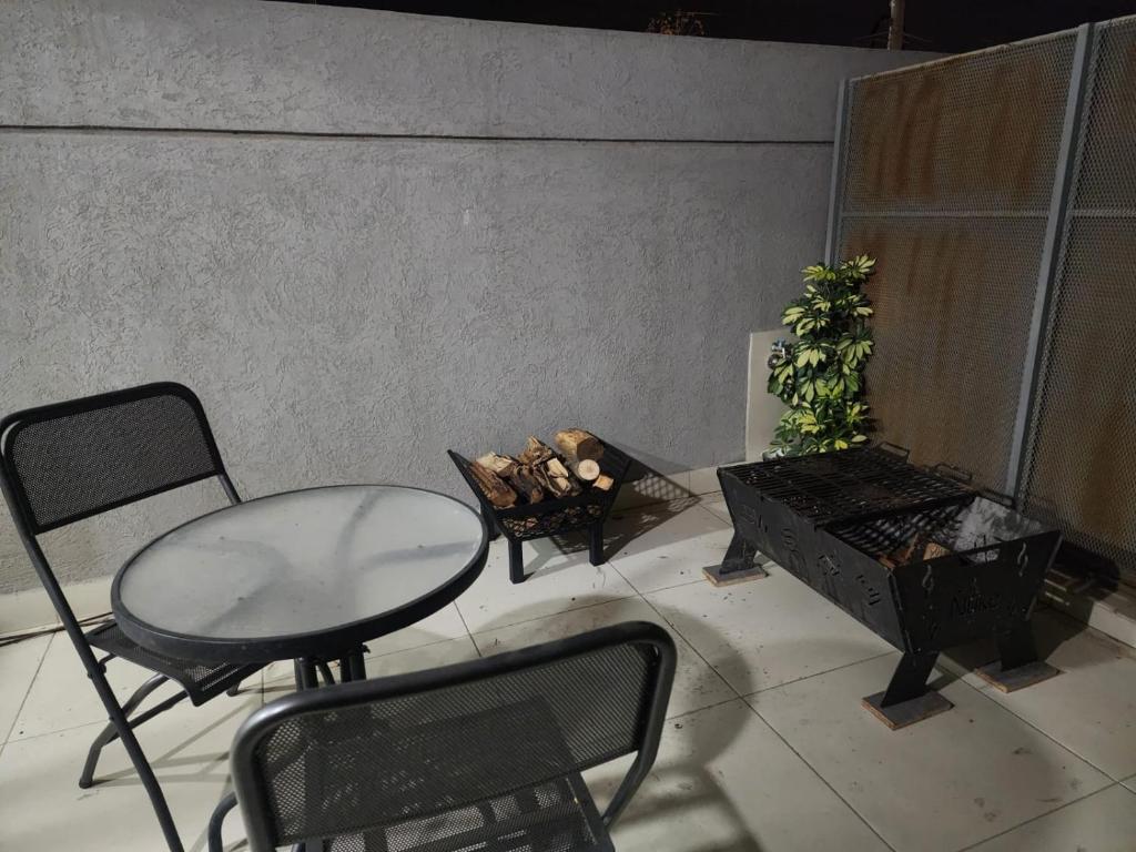 une terrasse avec une table, des chaises et une plante dans l'établissement Departamento excelente ubicación, à Godoy Cruz