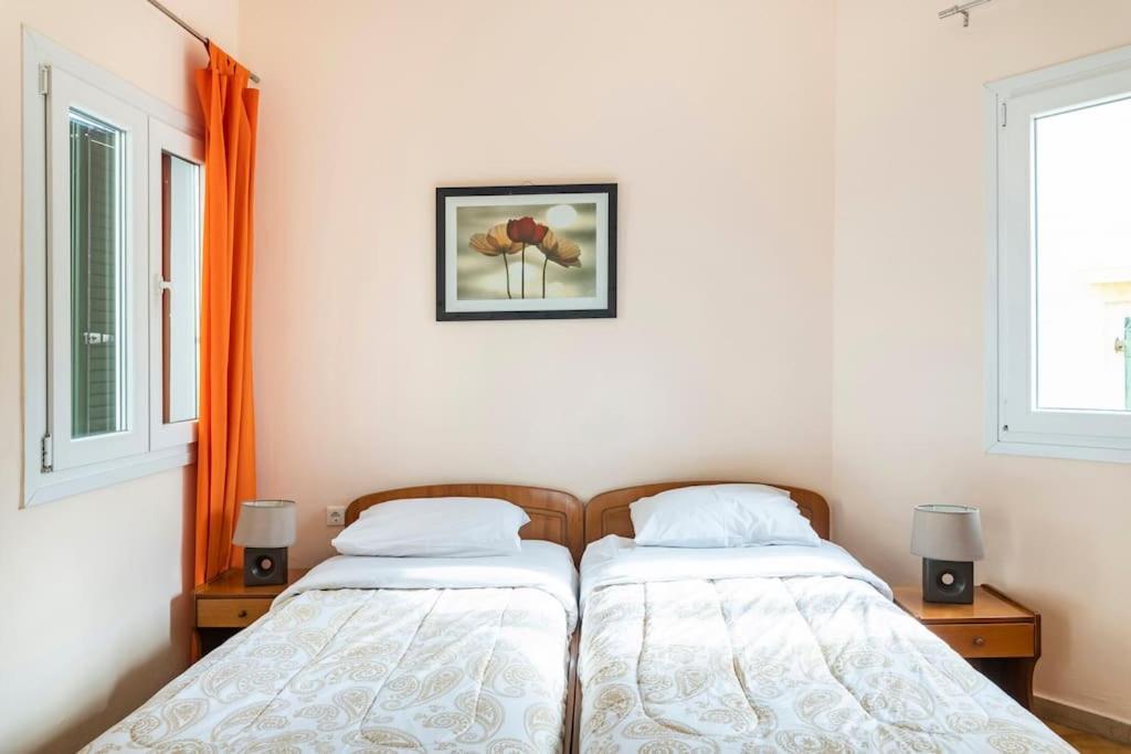 two beds in a room with two windows at Corfu Downtown in Corfu Town