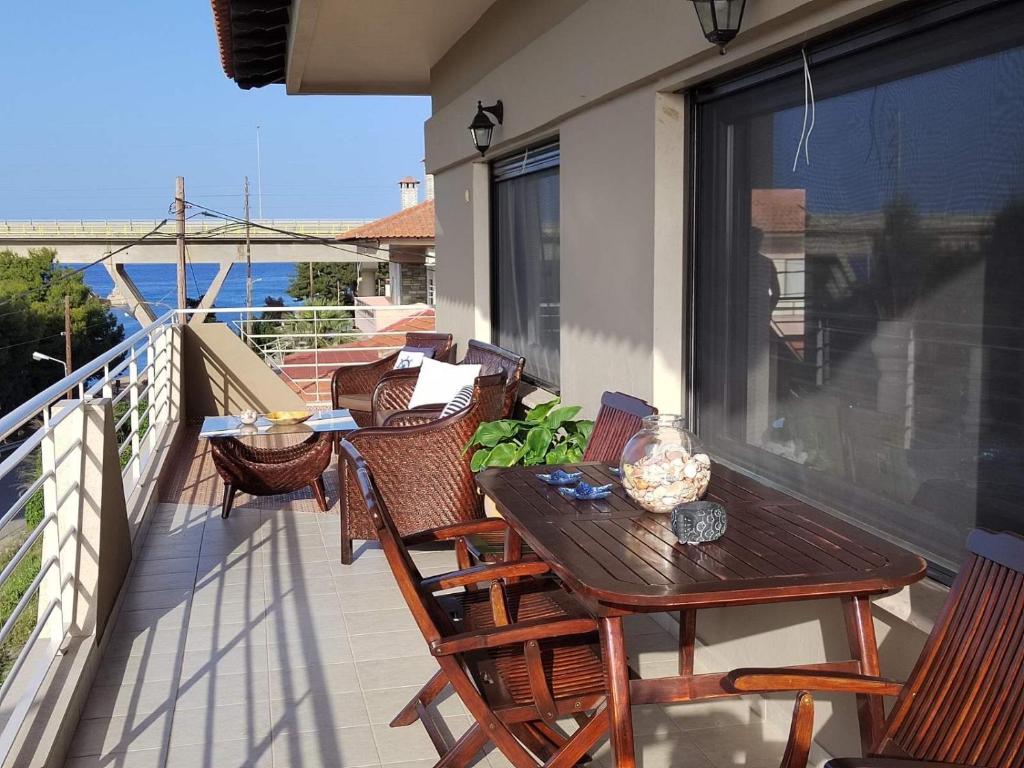 a balcony with a wooden table and chairs on a balcony at The house next to the canal ! in Nea Moudania