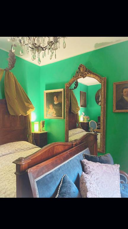 um quarto verde com 2 camas e um espelho em Art action room 