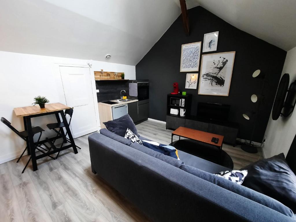 un salon avec un canapé bleu et une cuisine dans l'établissement Le Perdrix : Apt 2 prs, proche Gare et Darcy, à Dijon