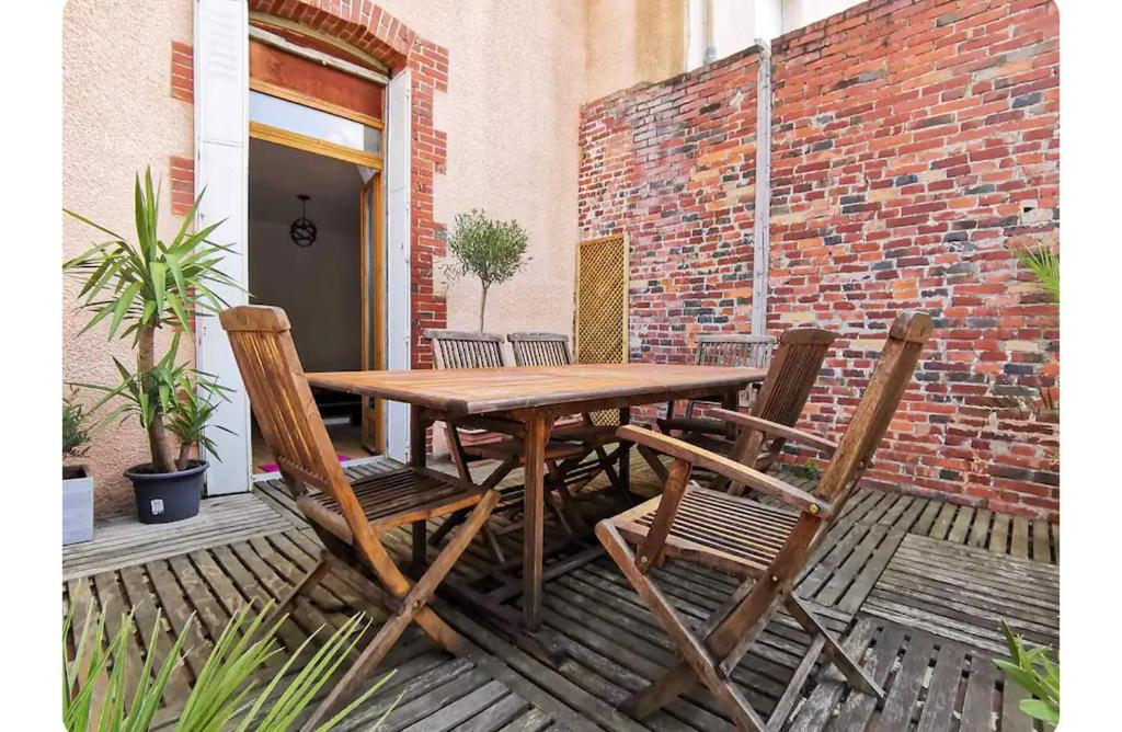 a wooden table and chairs on a patio at Chambre chez l'habitant tout confort aux Balcons de Bigorre in Tarbes