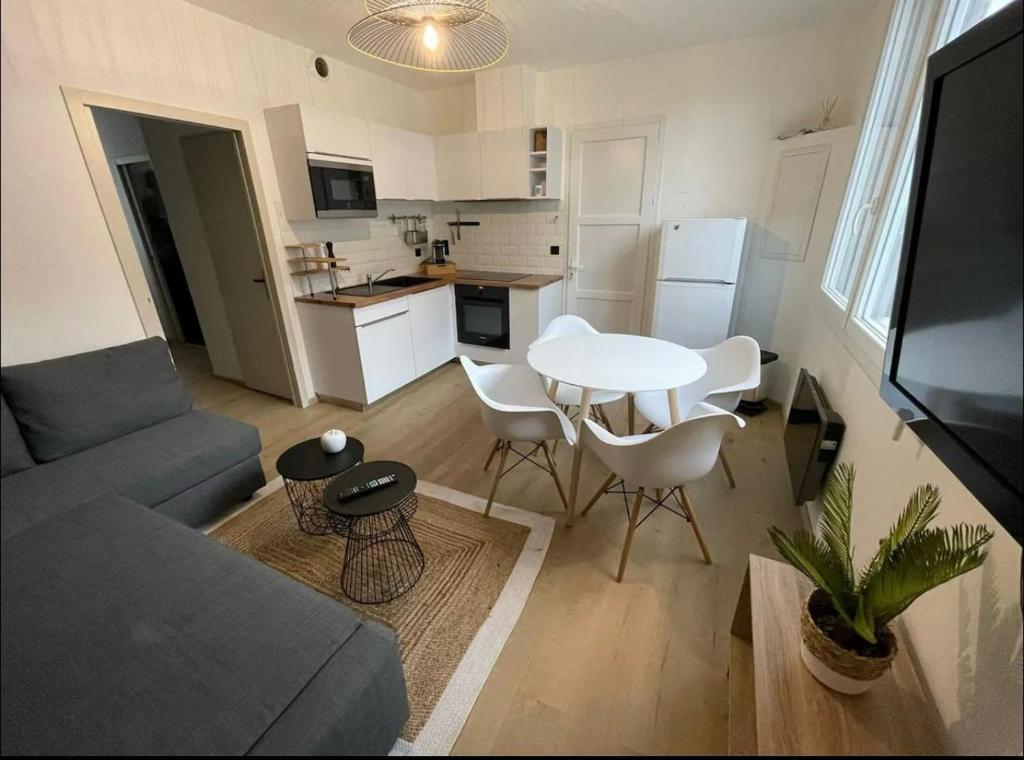 un salon avec un canapé et une table et une cuisine dans l'établissement La Belle Échappée, à Lourdes