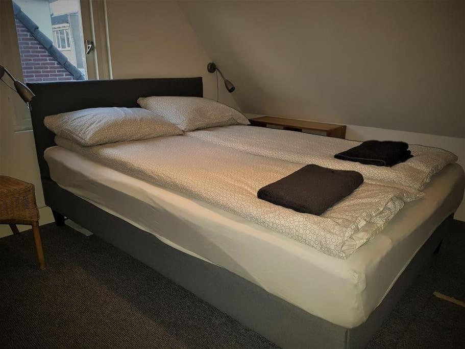 a bed in a room with two towels on it at Beach Cottage free parking in Noordwijk aan Zee