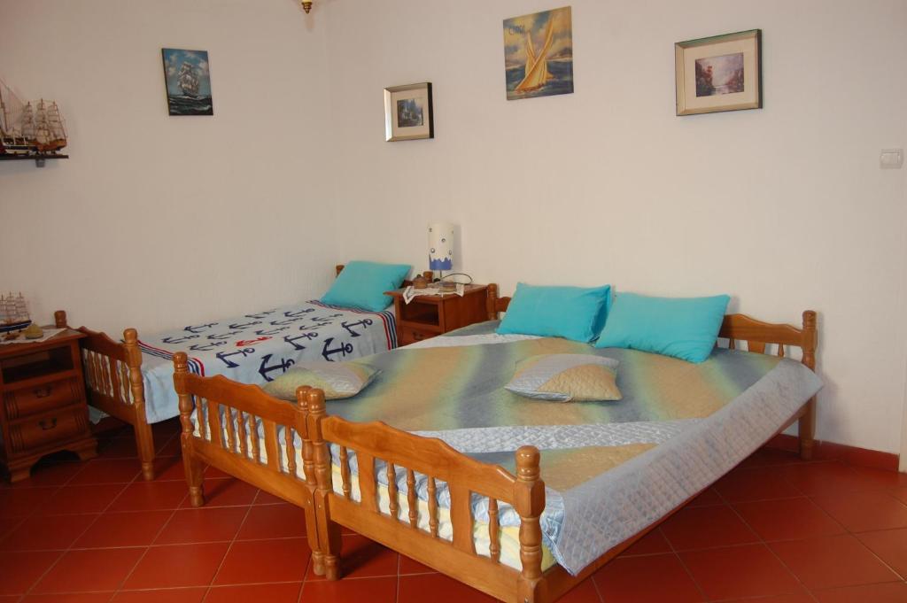 a bedroom with a large bed with blue pillows at Vila Montenegro in Dobra Voda