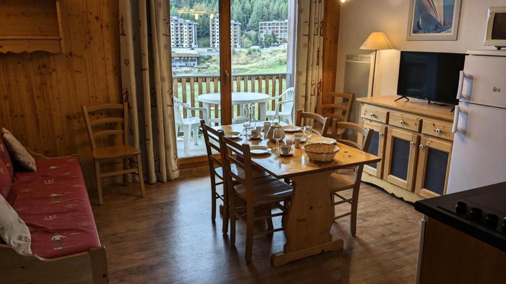 Il comprend une cuisine et une salle à manger avec une table et des chaises. dans l'établissement Résidence Les Terrasses De La Bergerie - Deux pièces cabine 6 personnes Terrasses de la Bergerie MAE-1731, à Orcières
