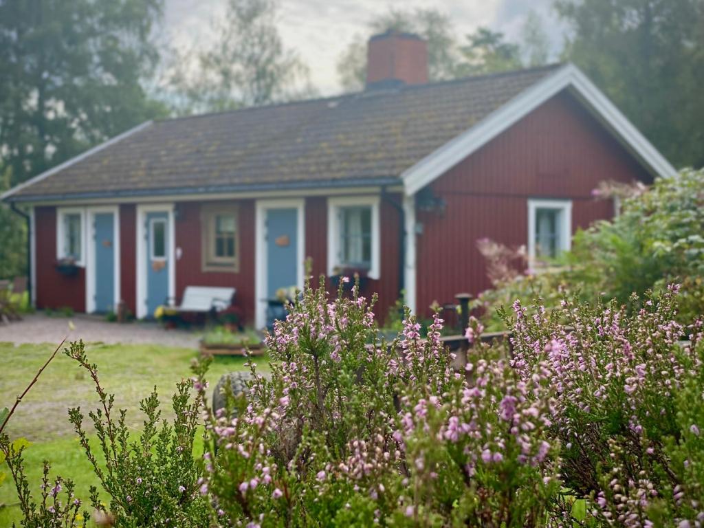 a red and white house with a garden and flowers at Ekologiska Fru Gran B&B i Tiveden in Gårdsjö
