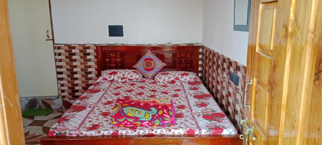 een kleine slaapkamer met een bed met een rode sprei bij Happy Morning Rohini Homestay in Kurseong