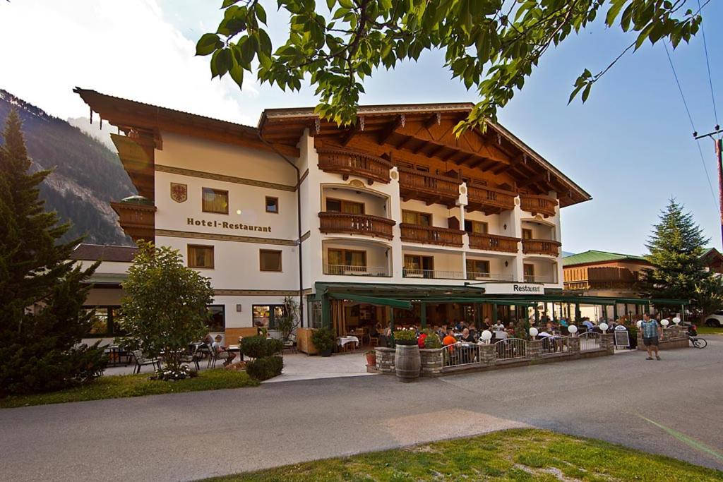 a large building with people sitting outside of it at Landhotel Denggerhof in Mayrhofen