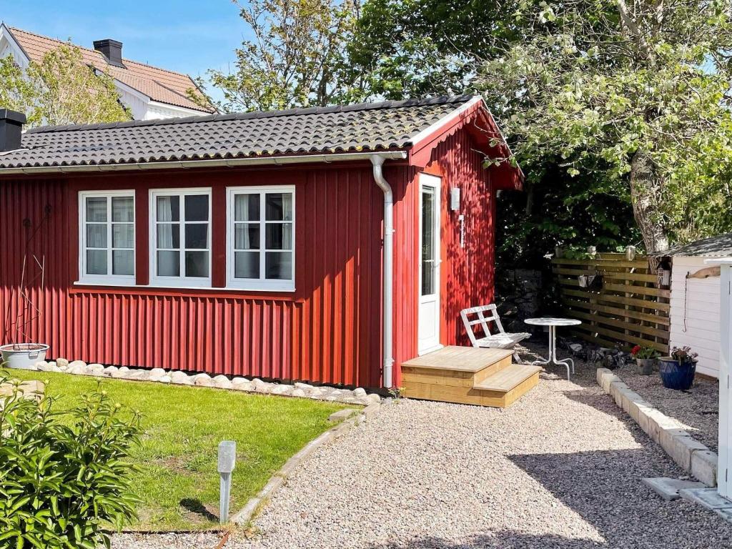 a red shed with a bench in a yard at 4 star holiday home in Öckerö-By Traum in Öckerö