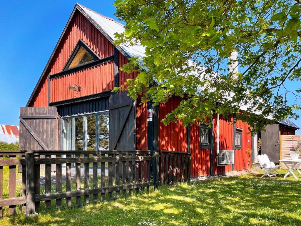 Czerwona stodoła z płotem przed nią w obiekcie Holiday home BORGHOLM XIX w mieście Borgholm