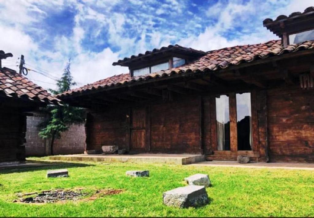 a large brick building with a green lawn in front of it at Cabañas Del Valle in Zacatlán