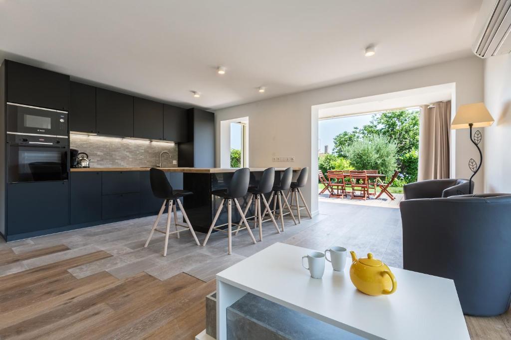 une cuisine et un salon avec une table et des chaises dans l'établissement Antibes Rez de Jardin, grande terrasse dans résidence avec piscine, à Antibes