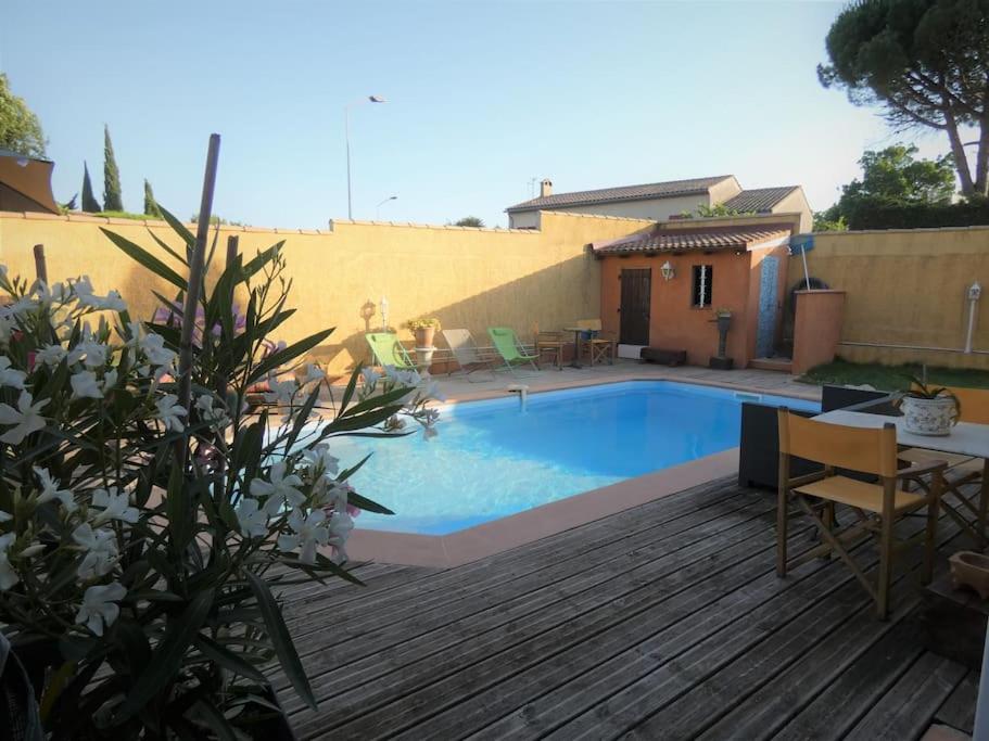 - une piscine dans un jardin avec une terrasse en bois dans l'établissement Maison TOMASELLO, à Carcassonne