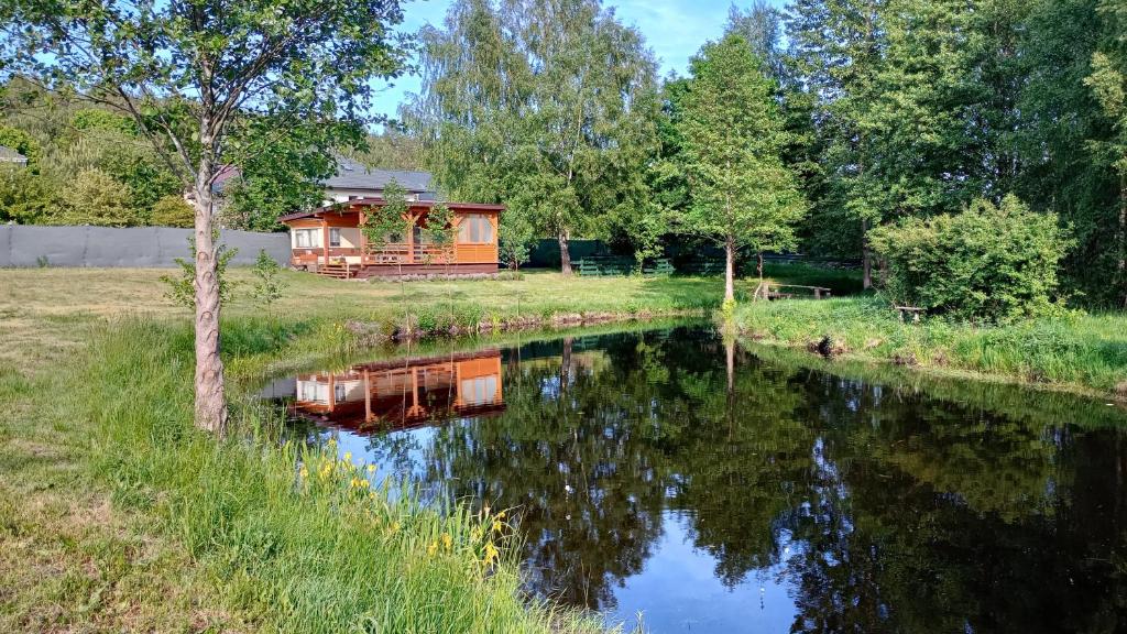 a cabin in the middle of a river with trees at Domek nad Stawami - Warmia in Jonkowo
