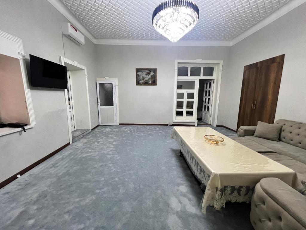 ein Wohnzimmer mit einem Sofa und einem Tisch in der Unterkunft STS-Family home guest house in Samarkand