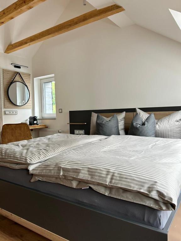 sypialnia z dużym łóżkiem z dużą białą narzutą w obiekcie Artemis Zimmervermietung 1 w mieście Sundern (Sauerland)