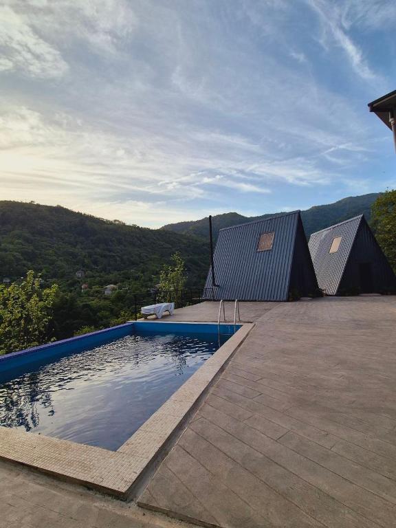 a swimming pool on a patio with a view of the mountains at Hill sunny2024 in Zemo Jocho