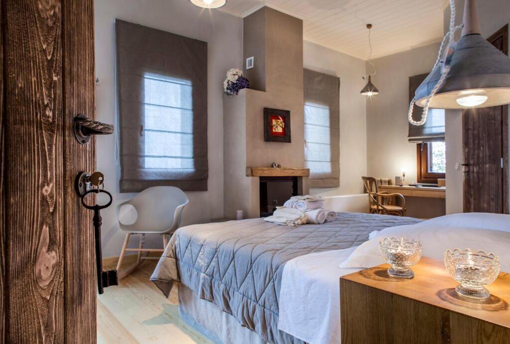 Un dormitorio con una cama y una mesa con gafas. en Kalderimi Country House, en Mouresi