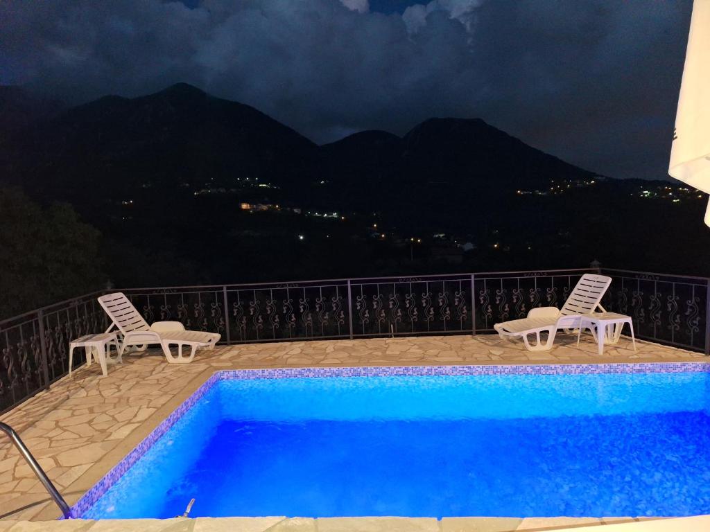 a swimming pool with two lawn chairs at Apartmani Dumezic in Bar