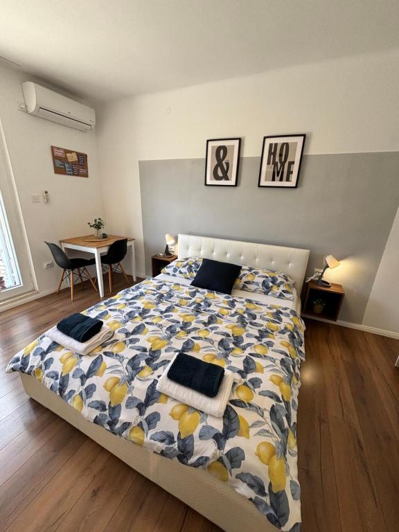 a bedroom with a large bed and a table at Studio Apartman LEMON in Dubrovnik