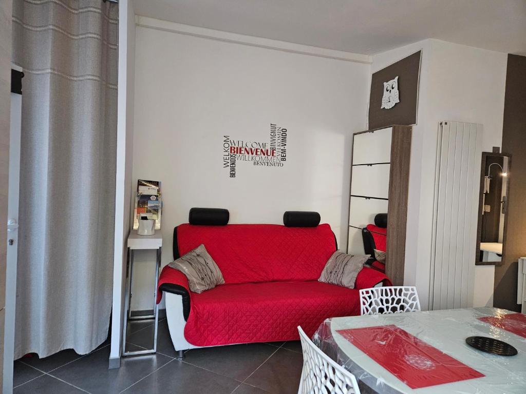 un salon avec un canapé rouge et une table dans l'établissement entre mer et montagne, à Saint-Estève